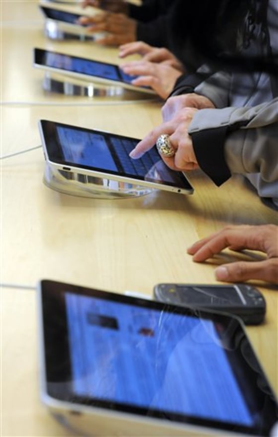 Shoppers experience the iPad at the Apple Store on Fifth Ave. in New York, Saturday, April 3, 2010. 